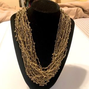 World Imports gold bead necklace. Beige string with tiny gold bugle beads.